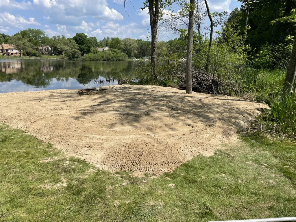 beautiful completed shoreline sandy beach, complete with fire pit on Little Walters Lake in Michigan.