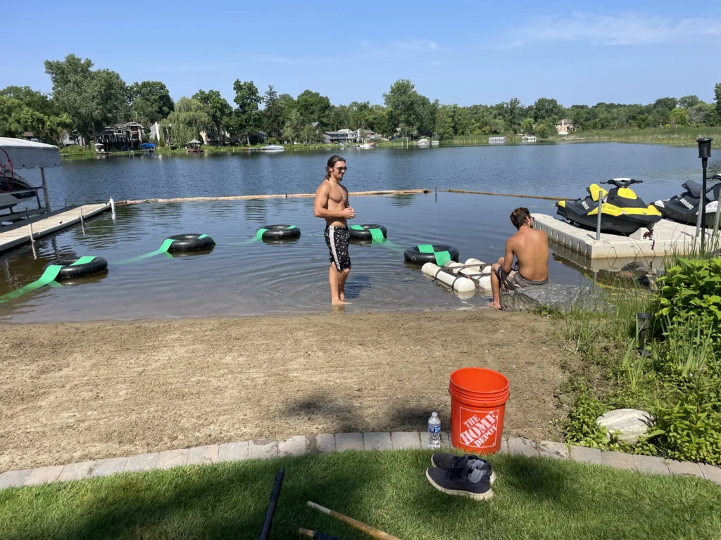 our crew actively placing sand onto the waterside beach.