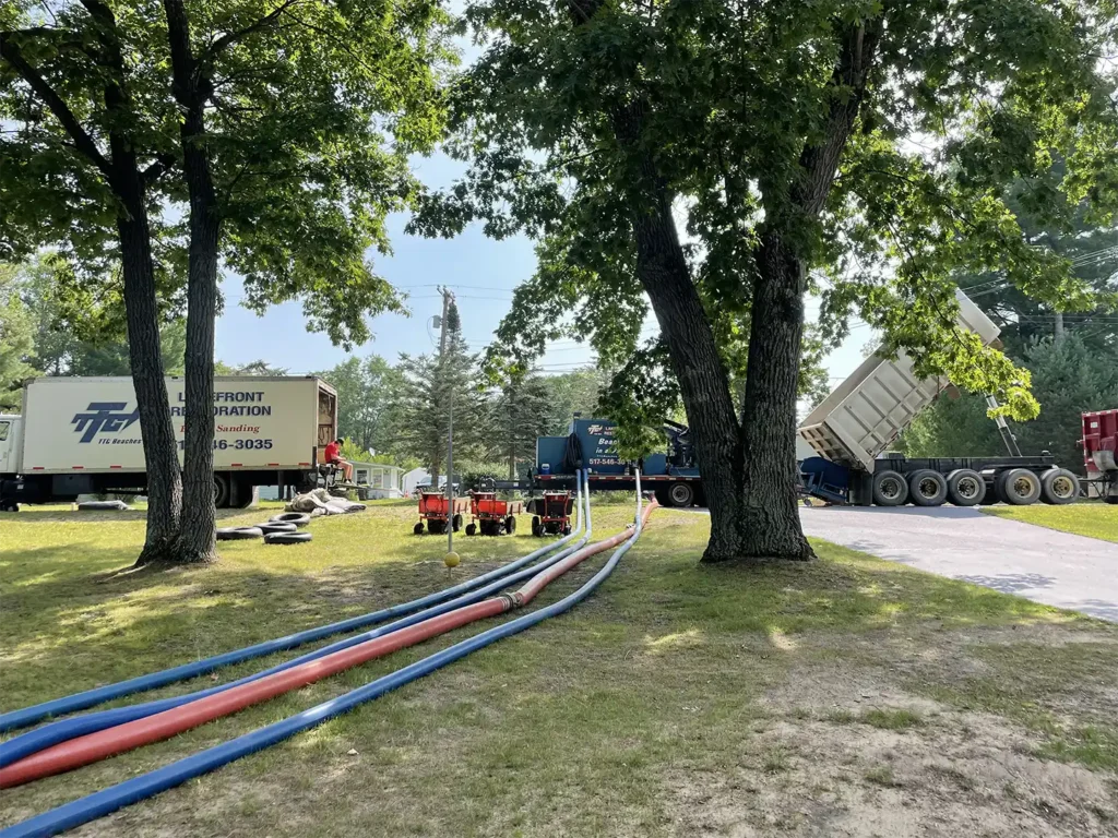 hoses running from the Sand Pro system parked on the street, all the way down to the water side beach we were sanding. The red hose carries the sand while the blue pumps in water.