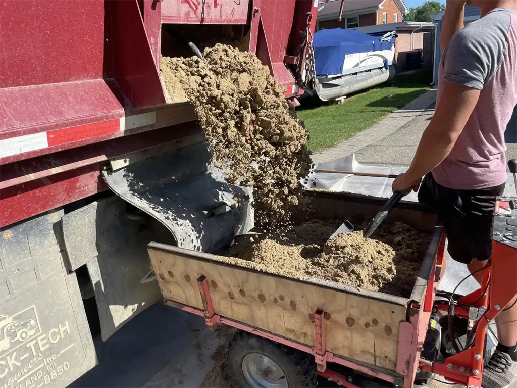 beach sand being loaded into a powercart for swift delivery to the shoreline.